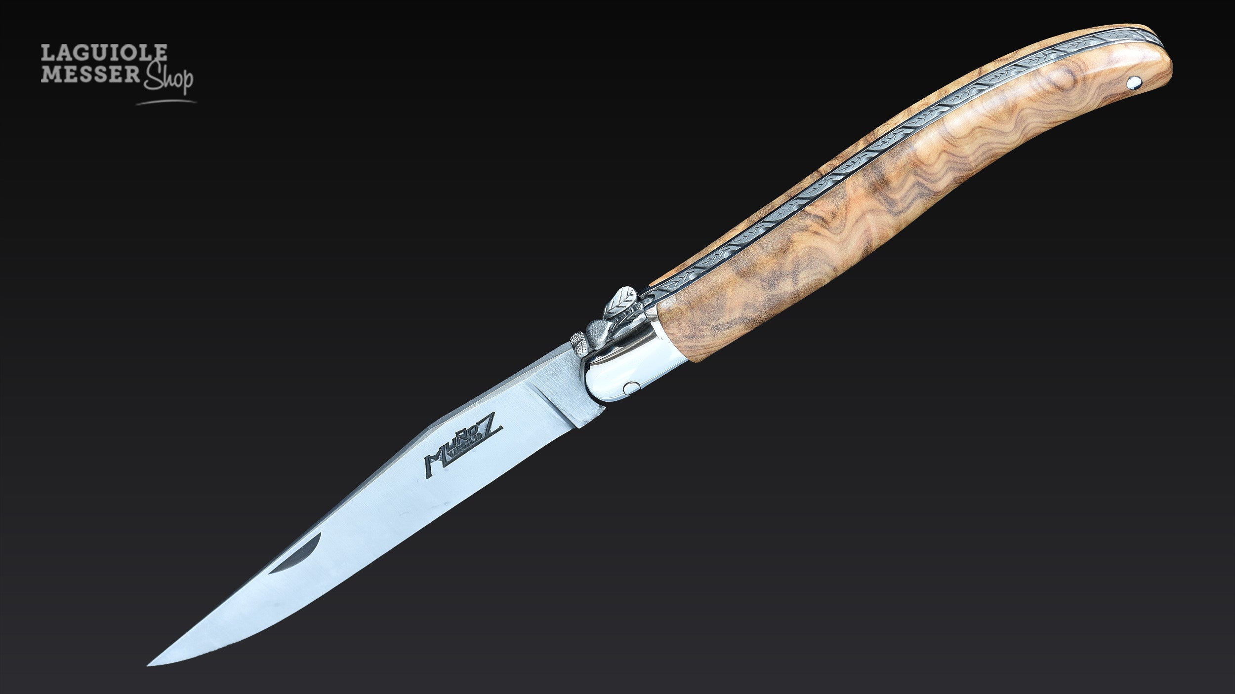 Laguiole Taschenmesser von Virgilio Muñoz mit Griff aus Olivenholz, geöffneter Klinge mit Signatur und fein gearbeiteter Mouche