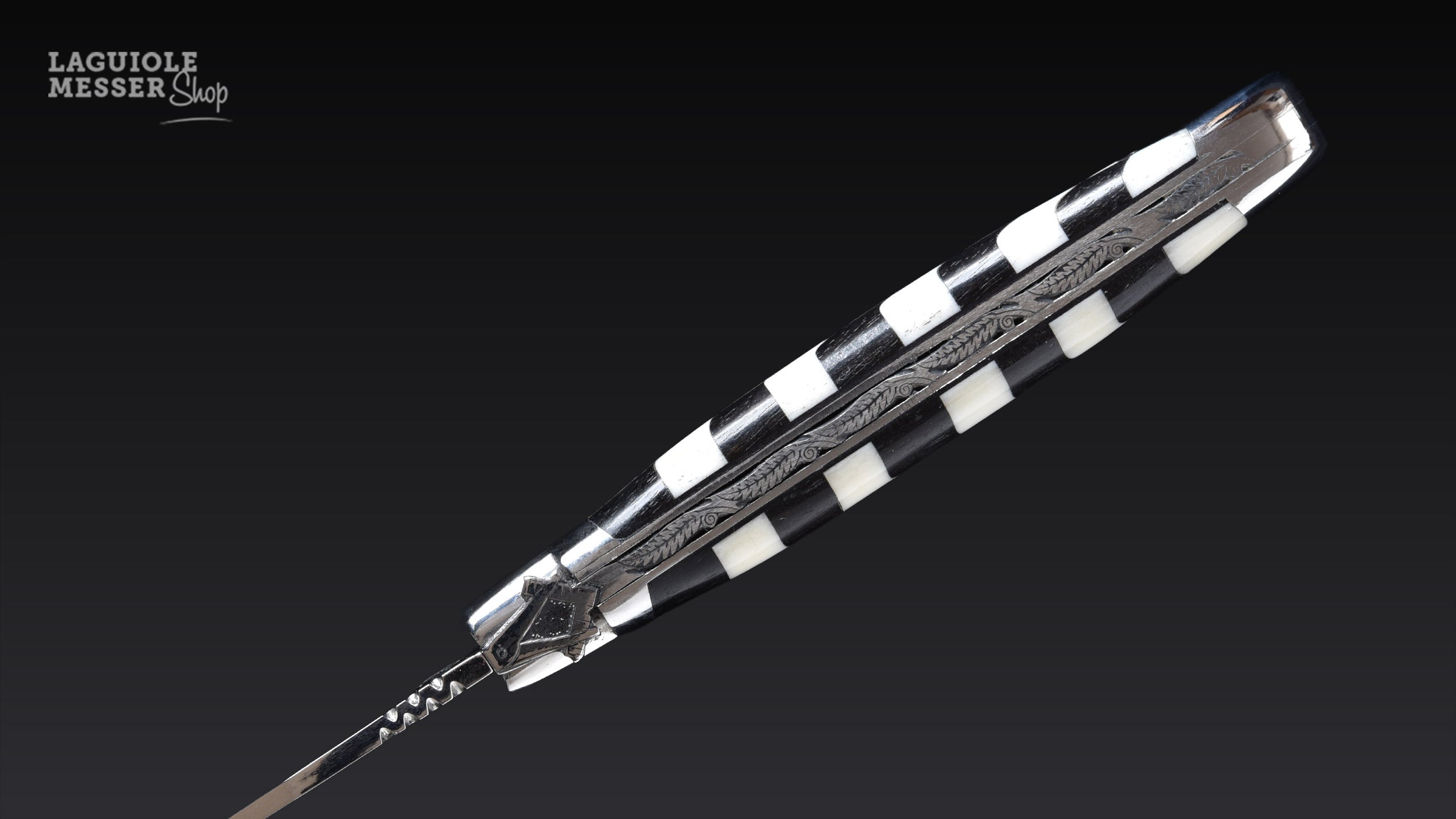 Detailaufnahme der geschmiedeten Freimaurer-Mouche mit Zirkel und Winkel sowie handverziertem Rücken bei Laguiole en Aubrac