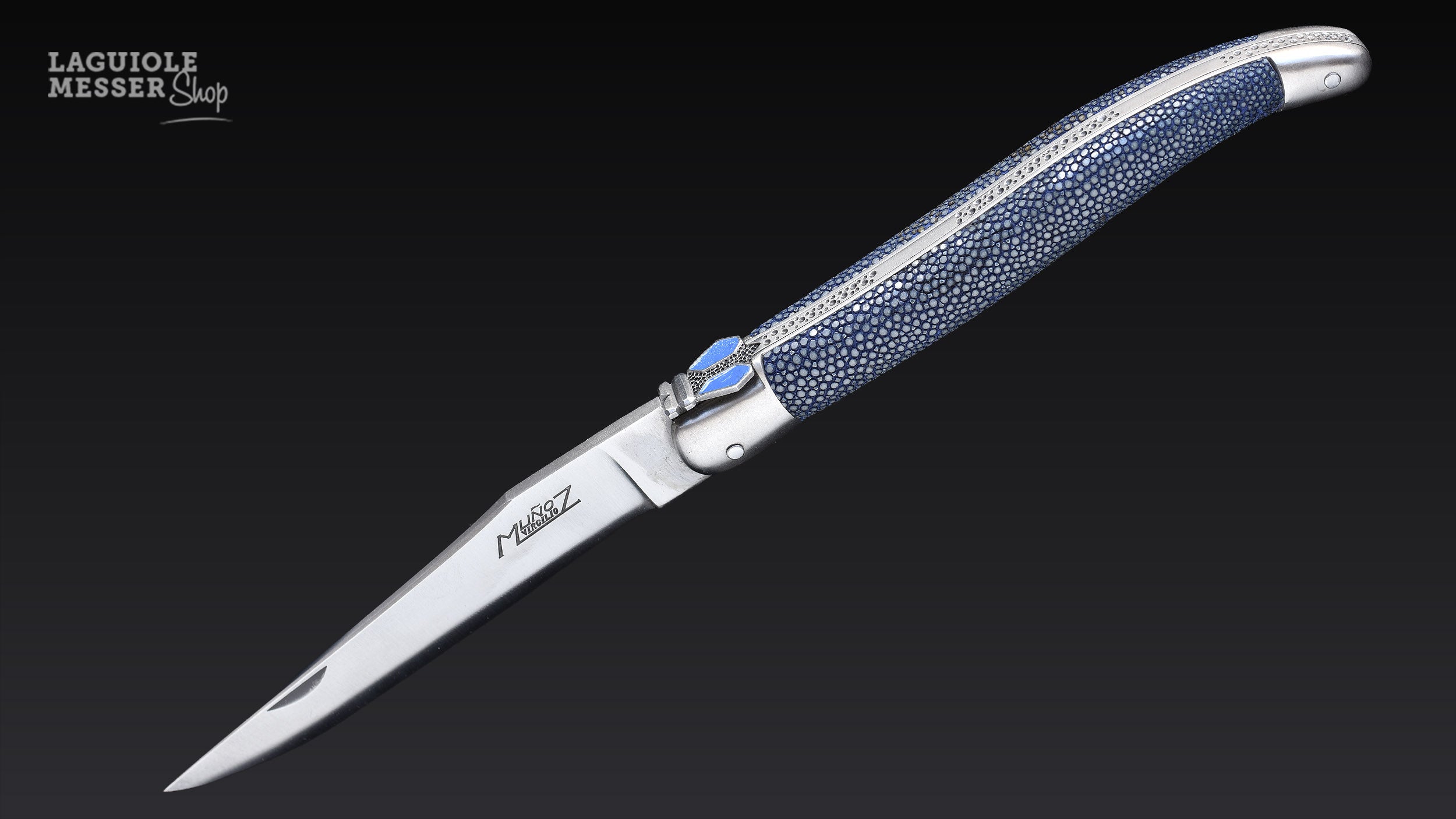 Laguiole Taschenmesser von Virgilio Muñoz mit blauem Galuchat-Griff, satinierten Backen und geöffneter Klinge mit Signatur